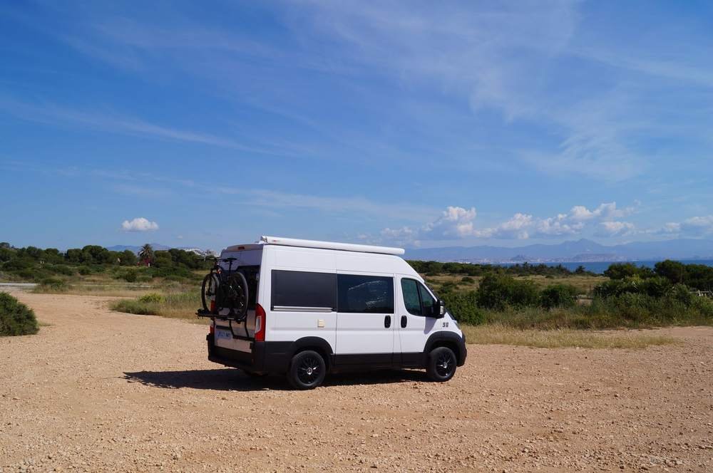 Fiat Ducato camper blanca de Domo Vans con el mar de fondo