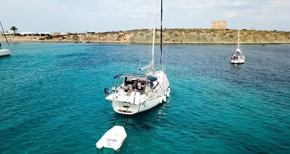 Velero fondeado en aguas transparentes junto a la isla de Tabarca